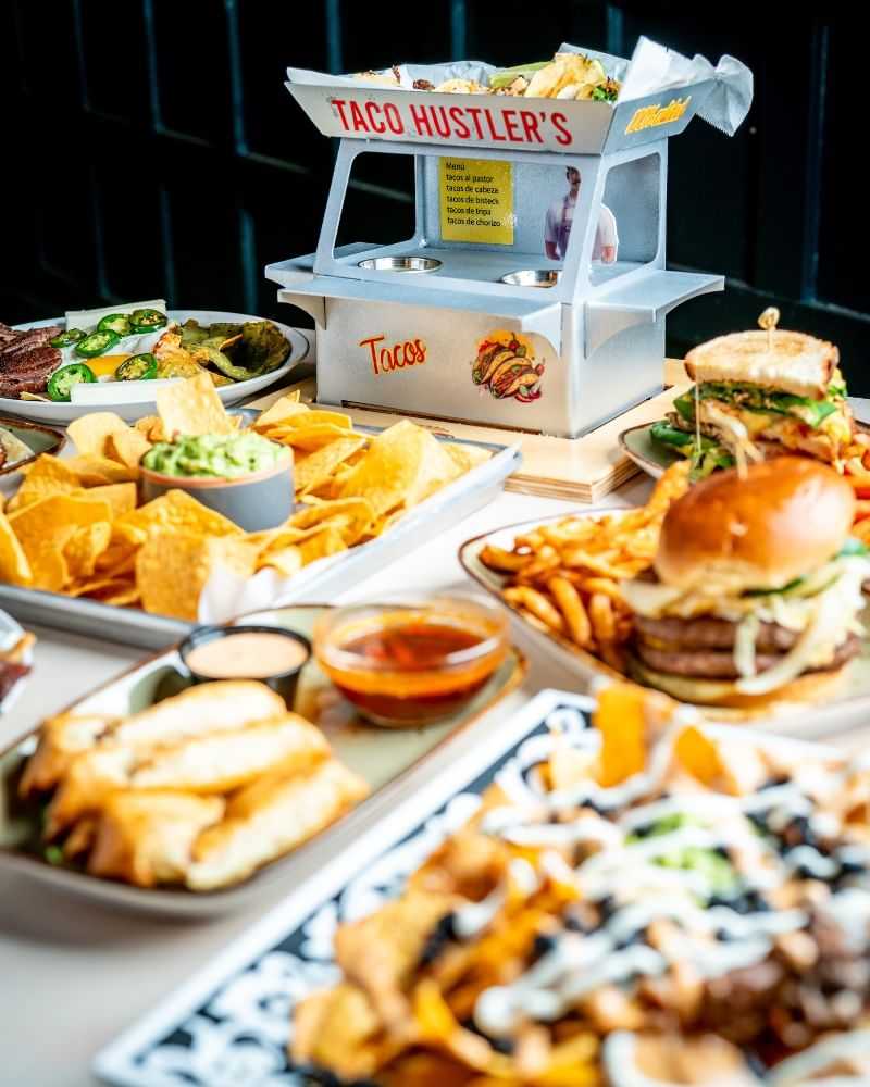 Delicious variety of tacos, burgers, and nachos displayed with vibrant presentation.